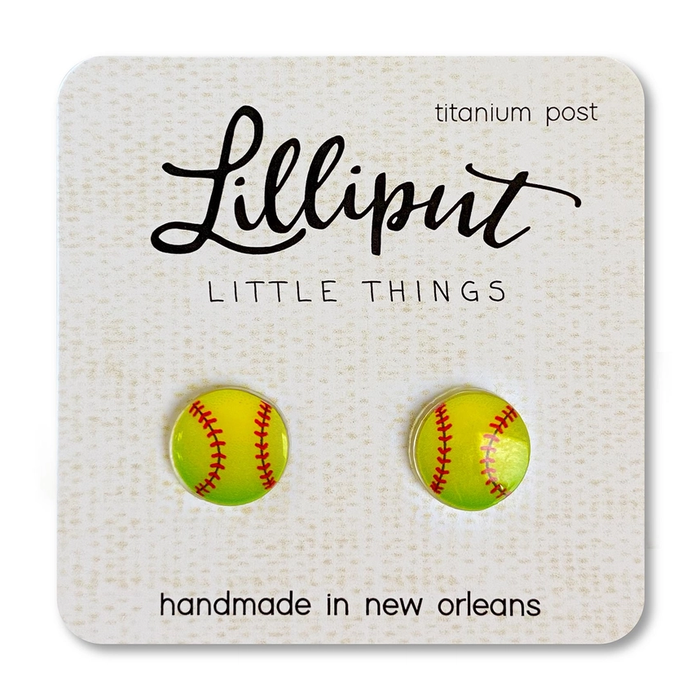 Lilliput Little Things Earrings feature hypoallergenic, handmade yellow softball shapes with red stitching, displayed on a branded card reading “Lilliput Little Things, titanium post, handmade in New Orleans.”.