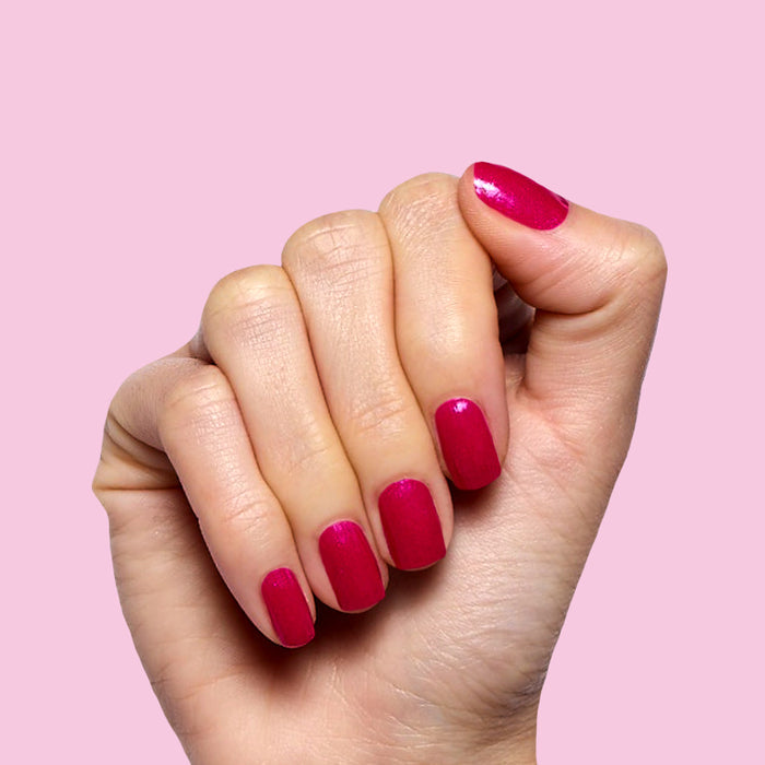 Lily Blooms deep magenta polish with a shimmering finish on natural nails for a long-lasting at-home mani