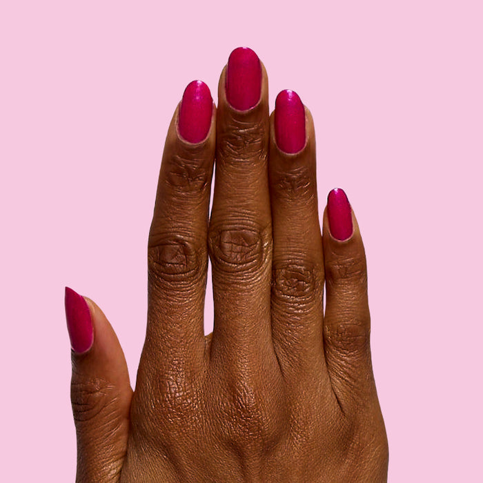 Lily Blooms bold magenta nail polish with a shimmering finish on natural nails for a long-lasting at-home manicure
