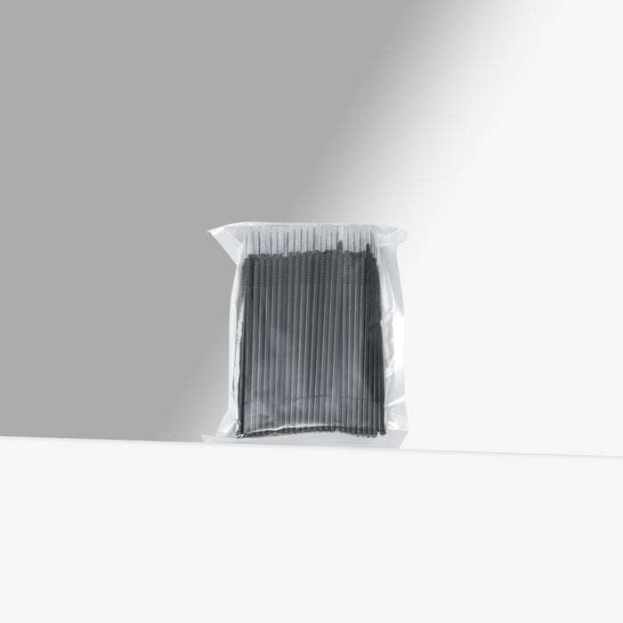 Clear plastic bag with black micro brushes on a gray background