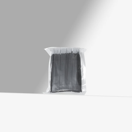 Clear plastic bag with black micro brushes on a gray background