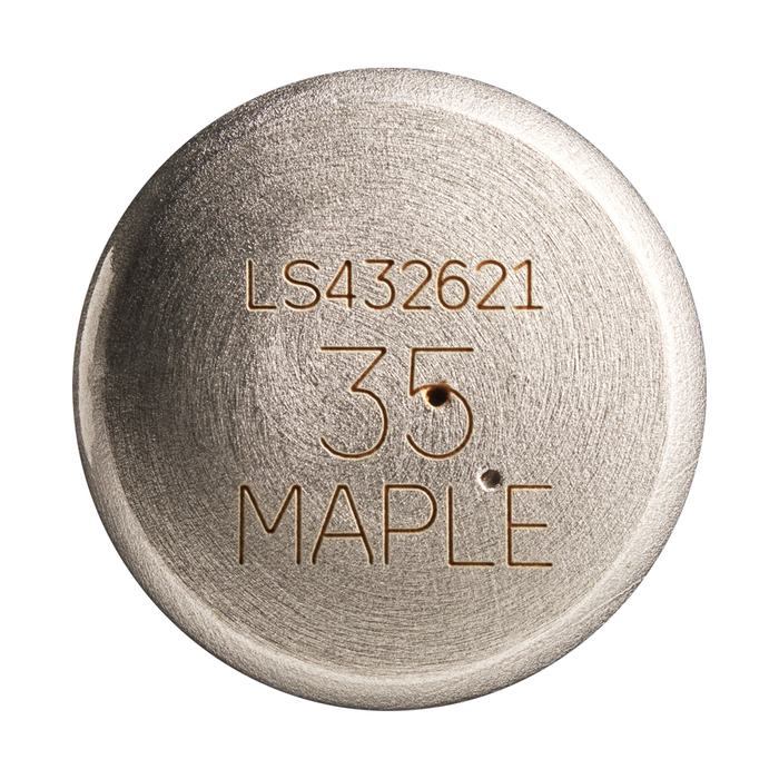 A round metallic object engraved with LS432621, 35, and MAPLE features a brushed texture and two small holes below the number, reminiscent of the classic craftsmanship of a Louisville Slugger Maple S345 Fungo 35″ Wood Training Bat.