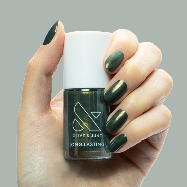 Hand holding Olive and June Martini Chrome nail polish with deep olive green and golden shimmer manicure