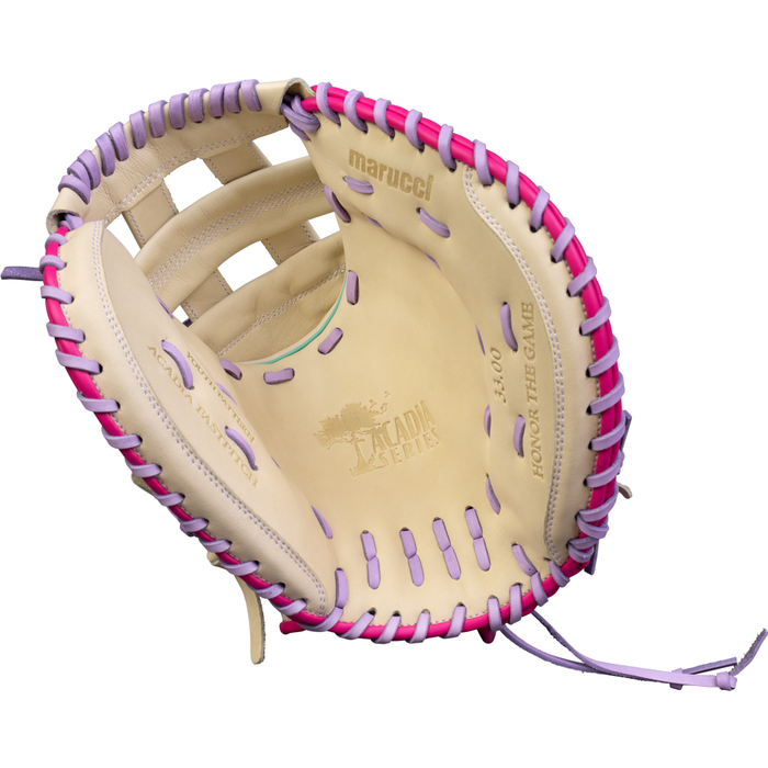 A Marucci Acadia 230C2 33″ Fastpitch Catcher’s Mitt (MFG4ACFP230C2-C/LP) made from full-grain cowhide leather in tan, featuring pink and purple lacing and “Marucci” plus “Honor The Game” stamped inside, held open to display the palm and webbing details.