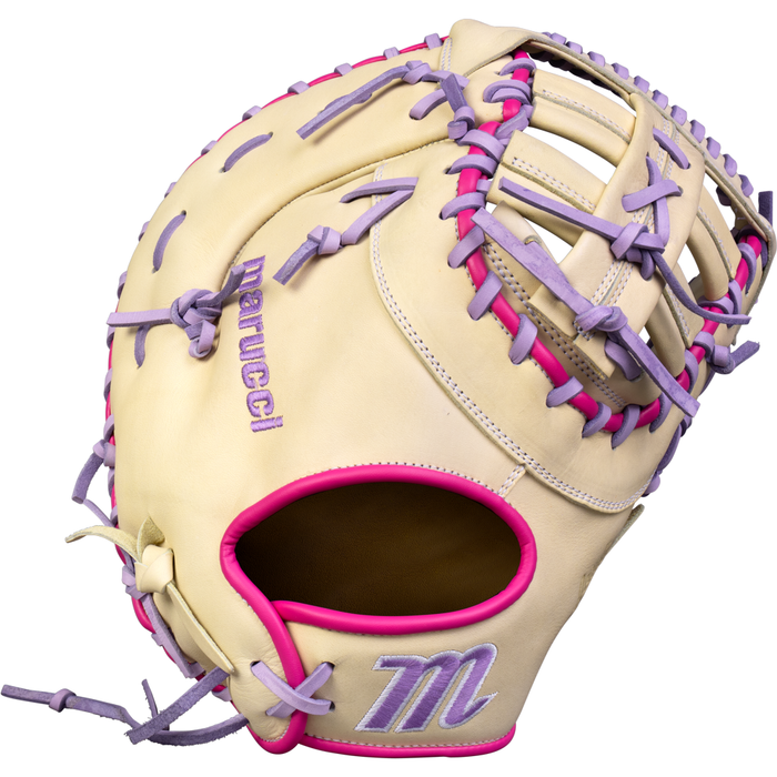 The Marucci Acadia 37S1 12.5″ Fastpitch First Base Mitt (MFG4ACFP37S1-CM/LP) features a cream-colored design crafted from premium full-grain cowhide leather, accented with pink and purple laces, pink trim around the wrist opening, and purple embroidered details—including the Marucci logo and brand name—plus an adjustable wrist closure for a secure, custom fit.
