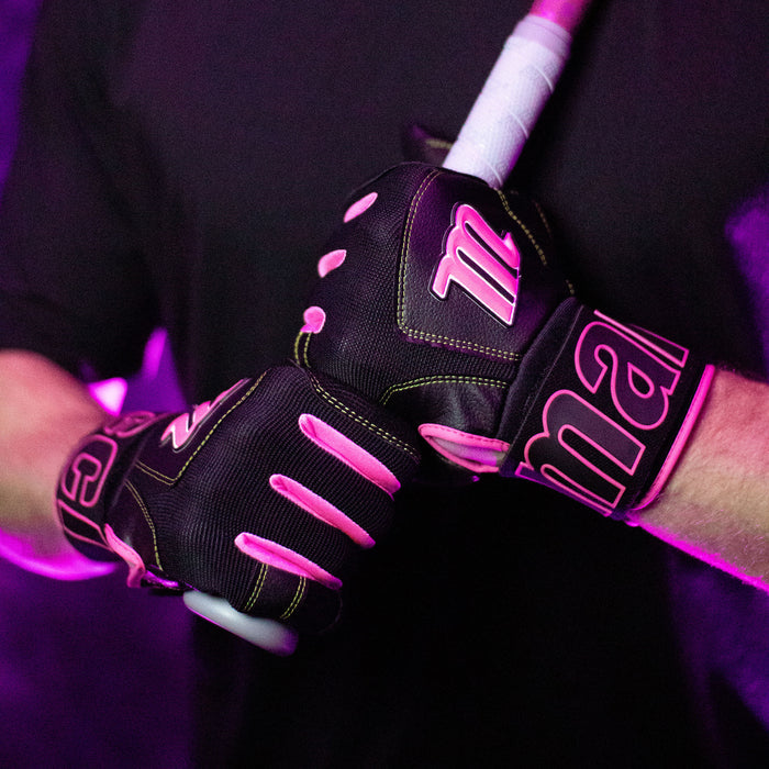 A person wearing Marucci Blacksmith V2 Full Wrap Adult Batting Gloves (MBG2BKSM) grips a baseball or softball bat with both hands, standing against a purple-lit background.