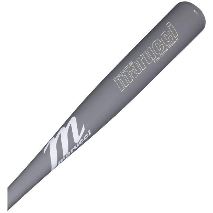 A close-up of the Marucci One-Hand Trainer Wood Bat: MONEHANDTB-GG—a gray training bat with the Marucci brand name and logo printed in white on the barrel—designed to enhance top-hand strength and hand-eye coordination during practice.