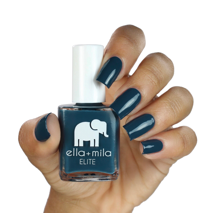 Mediterranean Mist dark teal nail polish on a medium skin tone, hand holding the bottle