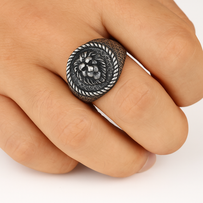 Antique lion head ring on a finger, featuring bold relief detail and antique finish.