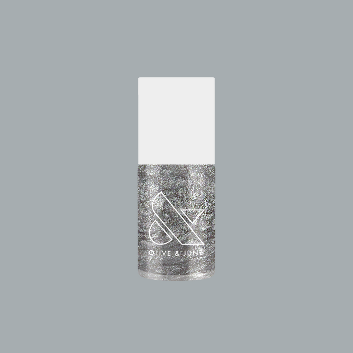 Olive and June Midnight Disco nail polish bottle with ultrafine silver glitter in clear base on gray background