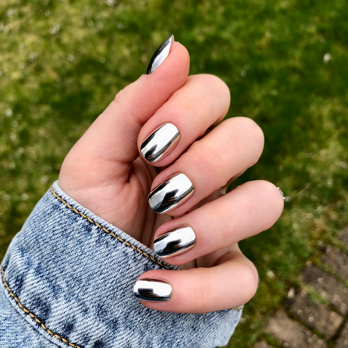 Mirror Chrome - Press-On | Extra Short | Round showing hand with reflective extra short round press-on nails in shiny chrome finish