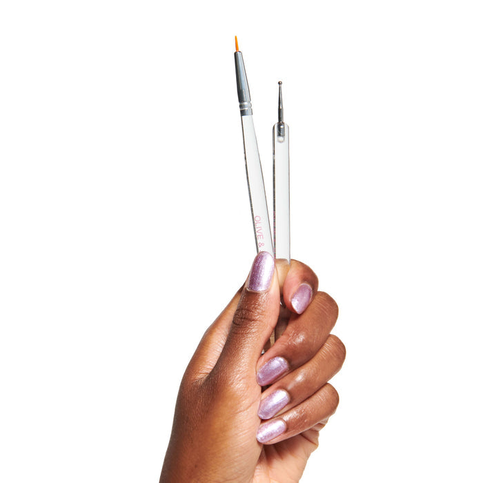 Hand holding Nail Art Brush Set with thin brush and dotting tool for detailed mani designs at home