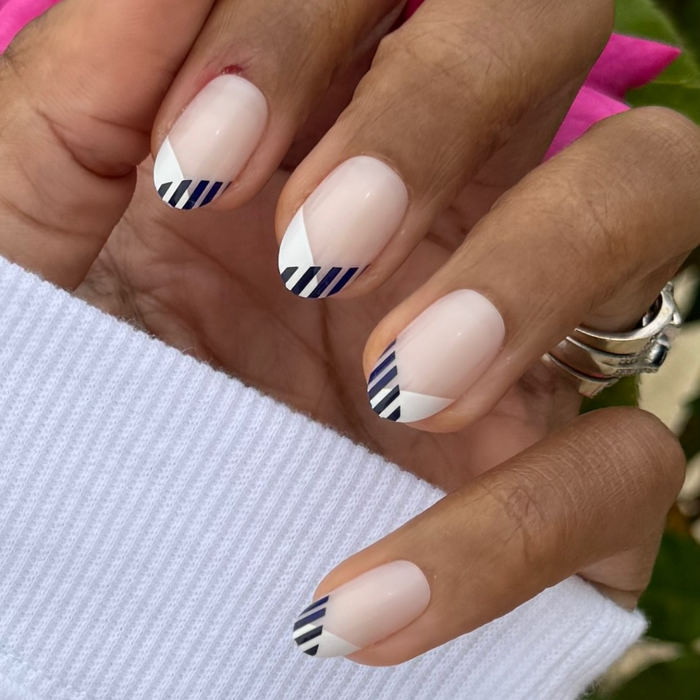 Nautical Split French - Press-On | Medium | Oval medium oval press-on nails with white and navy striped french manicure on hand