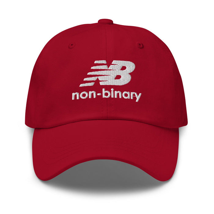A red baseball cap featuring a white embroidered 'non-binary' logo on the front, set against a plain white background.