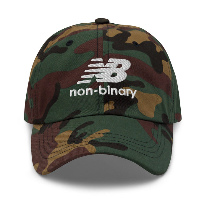A camouflage baseball cap featuring a white embroidered 'non-binary' logo on the front, set against a plain white background.