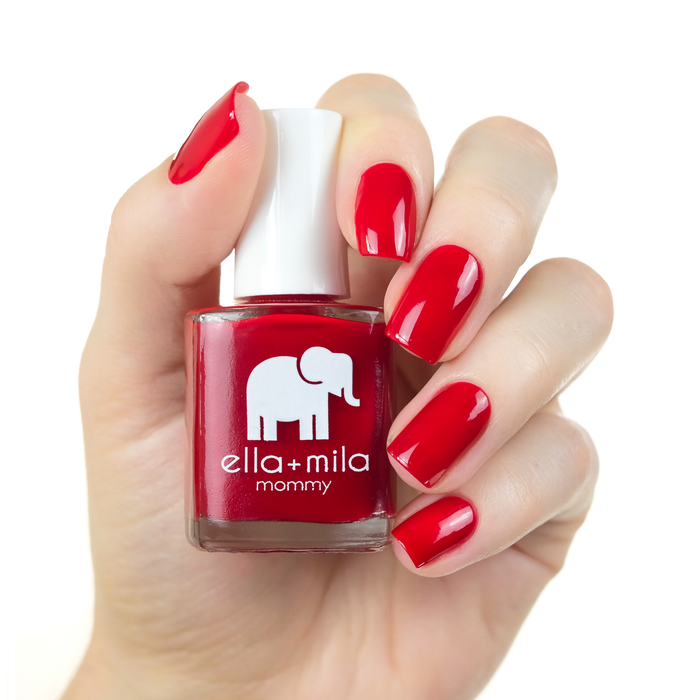 Paint the Town Red true red nail polish manicure on a light skin tone with the bottle