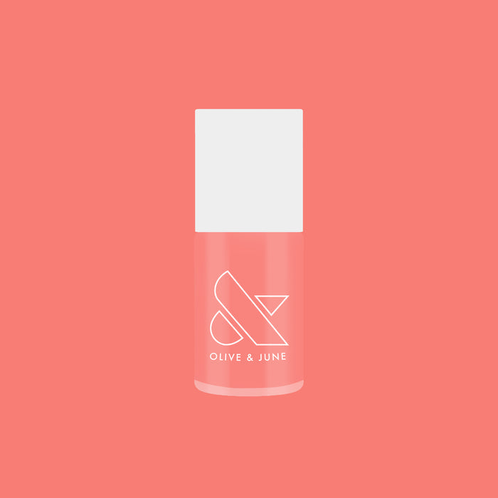 Olive and June Papaya Gloss sheer coral pink nail polish bottle against matching coral background for mani or pedicure