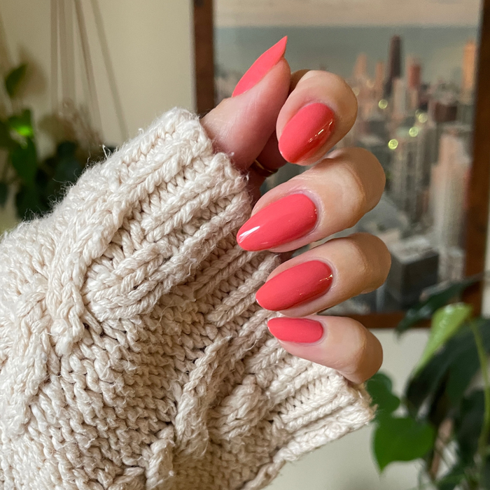 Perfect Pinwheel coral gel polish on almond-shaped nails with a shiny finish for a cheerful at-home manicure