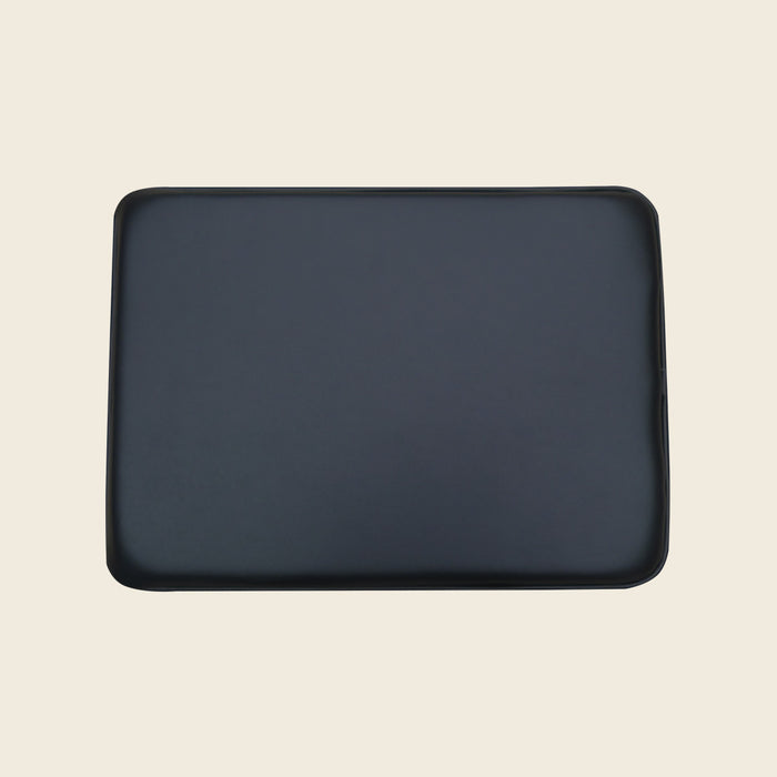 Black upholstered Gratz Pilates pillow for the Electric Chair on a beige background.
