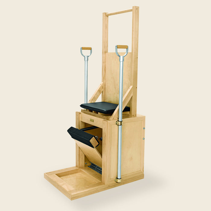 Black upholstered pillow resting on the seat of a wooden Pilates Electric Chair.