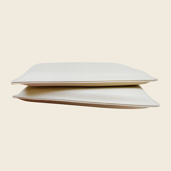 Cream upholstered Pilates headrest pillow with a sleeve that slides over a reformer headrest.