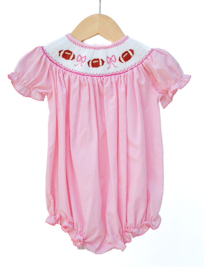 Girl's pink gingham game day bubble with a hand-smocked football and bow neckline, a timeless heirloom look