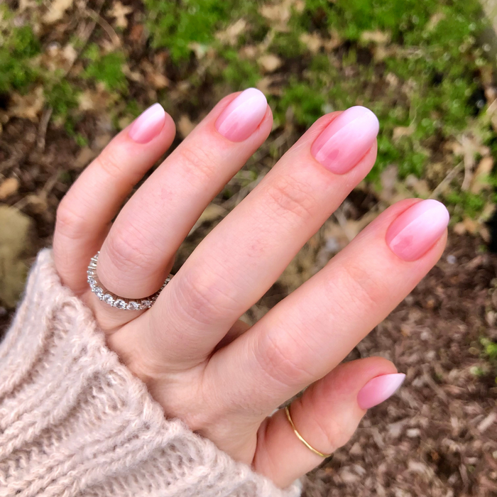 Pink Syrup Gradient - Press-On | Extra Short | Round showing hand with extra short round pink to white gradient press-on manicure outdoors