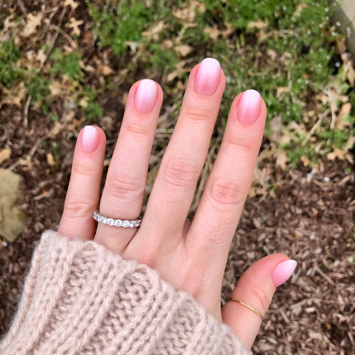 Pink Syrup Gradient - Press-On | Extra Short | Round showing hand with extra short round pink to white gradient press-on manicure outdoors
