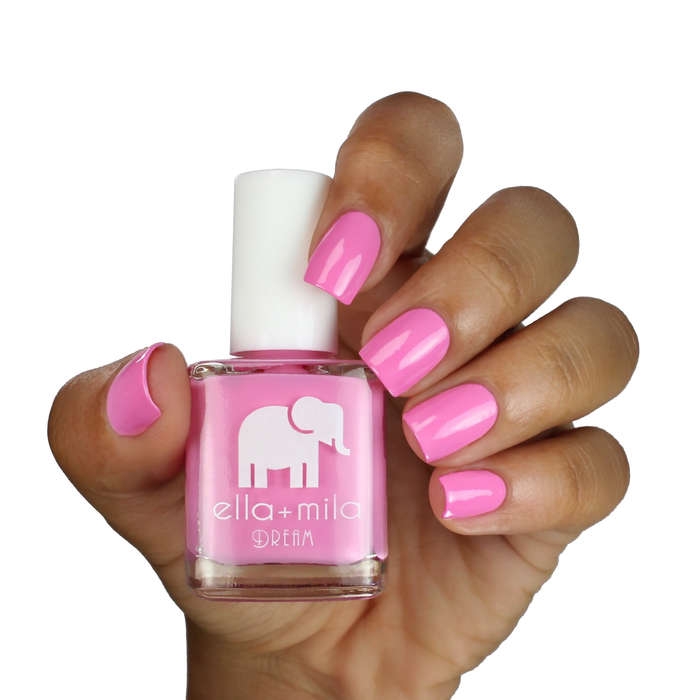 Pinkterest+ bubblegum pink nail polish on a medium-deep skin tone, hand holding the bottle