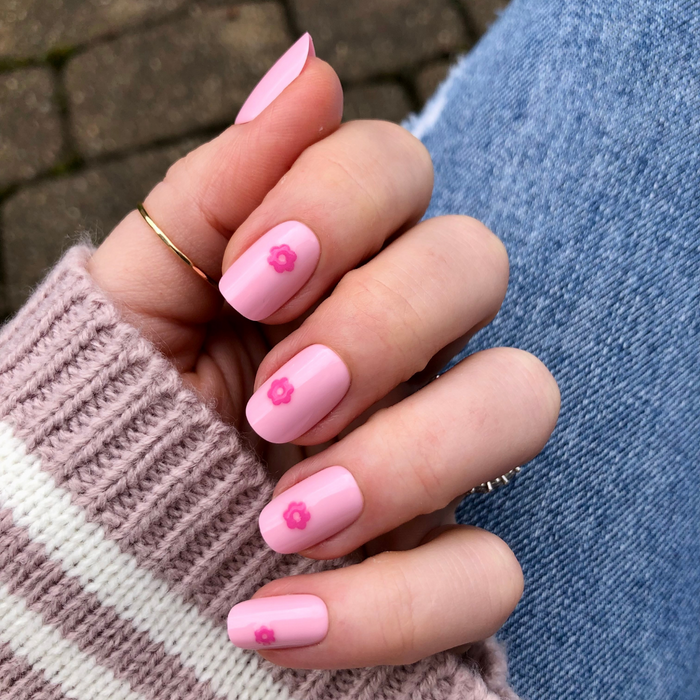 Puffy Daisy - Press-On | Short | Squoval showing hand with short squoval nails in pink polish and small hot pink flower decor