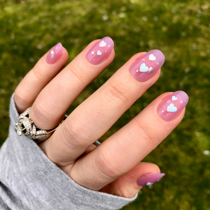 Puffy Hearts - Press-On | Short | Round showing hand with sheer lavender short round press-on nails decorated with raised hearts