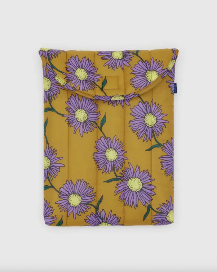 Mustard-yellow puffy 13"/14" laptop sleeve with purple daisy pattern and top flap.