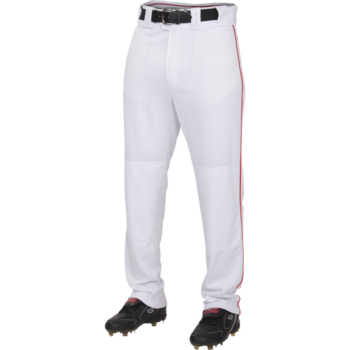 A person wears Rawlings Adult Premium Semi-Relaxed Baseball Pants with Piping (PRO150P), made of 100% polyester with a thin red stripe, paired with a black belt and black cleats, standing against a plain white background.