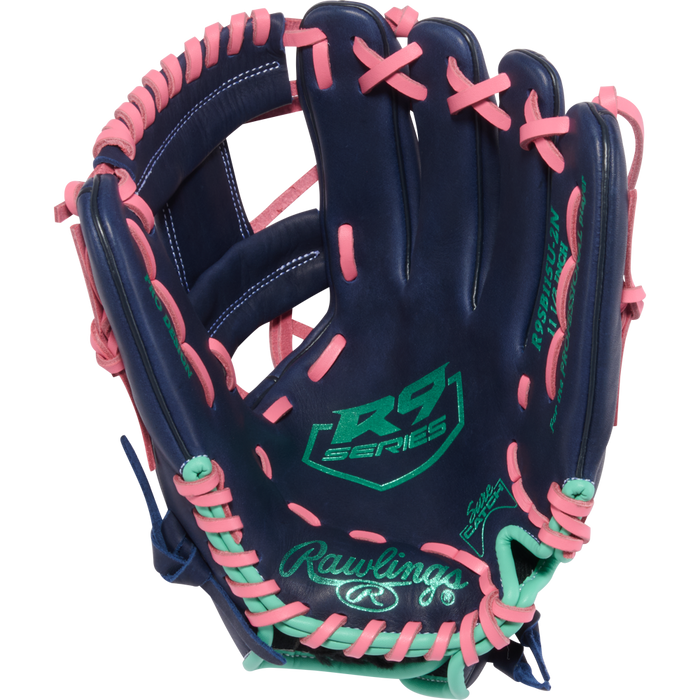 The Rawlings R9 11.5" Fastpitch Glove (R9SB115U-2N) features a navy blue design with pink laces, mint green accents, and the embroidered Rawlings logo plus signature palm details.