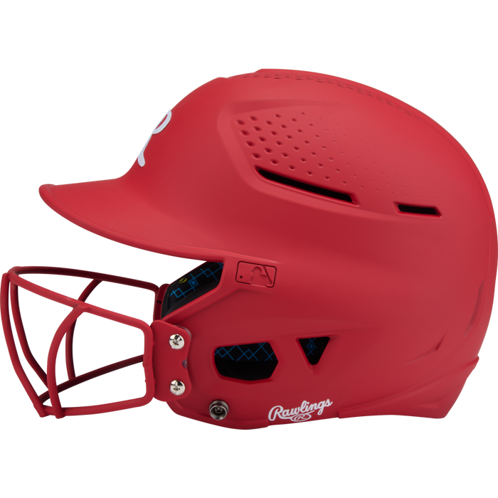 The Rawlings RX2 Matte Batting Helmet with Fastpitch Mask (RX2SBMAT) is shown in side profile, featuring ventilation holes and a white Rawlings logo near the ear, set against a plain background.