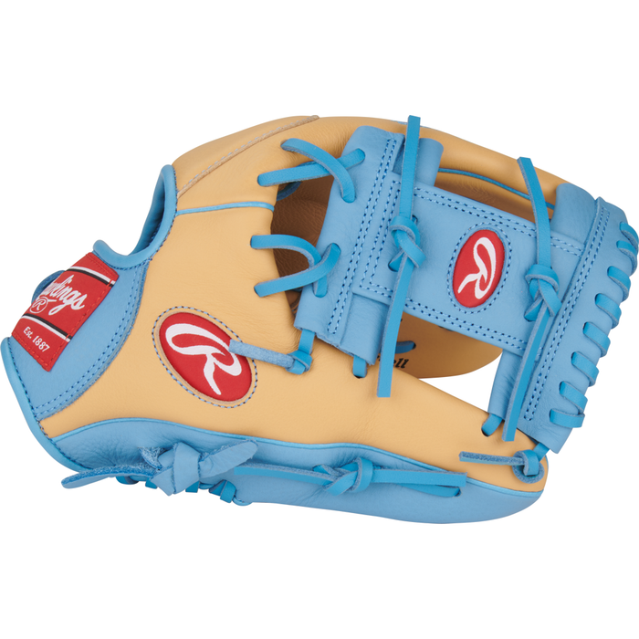 The Rawlings Select Pro Lite 11.5″ Francisco Lindor Baseball Glove: SPL150FLC is showcased against a white background, featuring a tan and light blue design with blue laces and red Rawlings logos on the wrist strap and thumb area. Inspired by Francisco Lindor’s pro glove, this youth infield baseball glove from Rawlings offers young players a combination of eye-catching style and professional-level features.