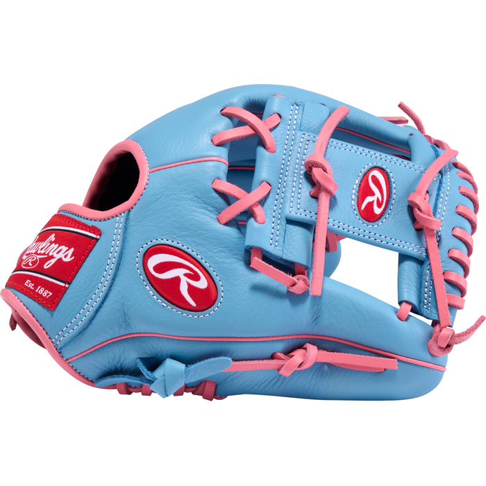 A Rawlings Select Pro Lite 11.5″ Manny Machado Baseball Glove (SPL150MMCB) in light blue, featuring pink laces and red Rawlings logos, inspired by Manny Machado’s glove, is displayed on a white background.