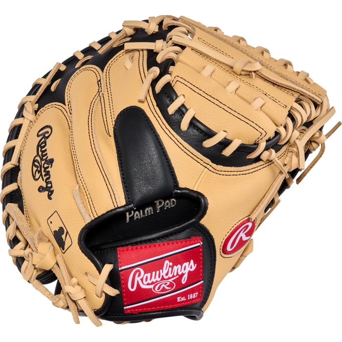 A tan and black Rawlings Select Pro Lite 32″ Cal Raleigh Baseball Catcher’s Mitt (SPLCM32CR) with white laces, highlighted by a red Rawlings logo patch, Palm Pad text, and the MLB logo on the side. This youth catcher’s mitt from Rawlings is designed to provide outstanding durability and comfort for young baseball players behind the plate.