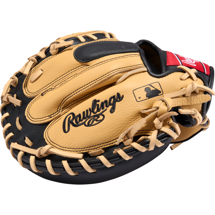A tan and black Rawlings Select Pro Lite 32″ Cal Raleigh Baseball Catcher’s Mitt (model SPLCM32CR), featuring laces and the MLB logo, is displayed against a white background.