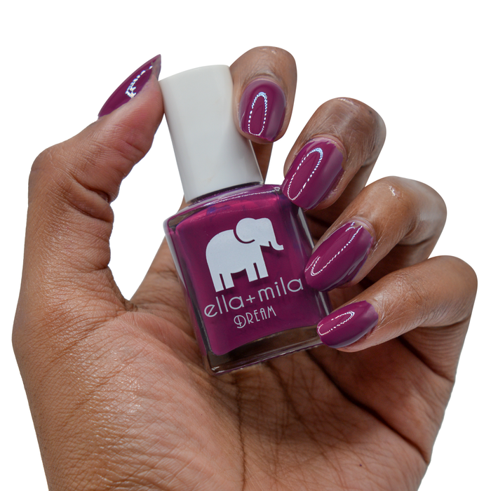 Rising Violet violet nail polish on a deep skin tone, hand holding the bottle