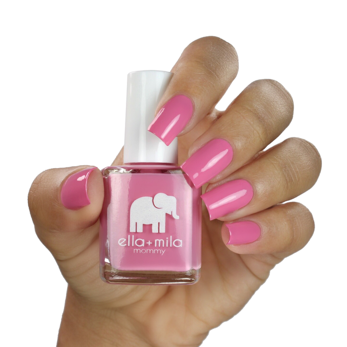 Rosy Cheeks pink nail polish on a medium skin tone, hand holding the bottle