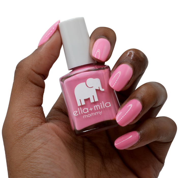 Rosy Cheeks rosy pink nail polish on a deep skin tone, hand holding the bottle