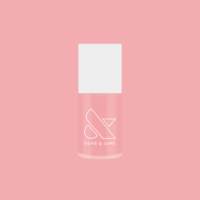 Bottle of Saltwater Taffy sheer pink gel polish by Olive and June displayed against pink background