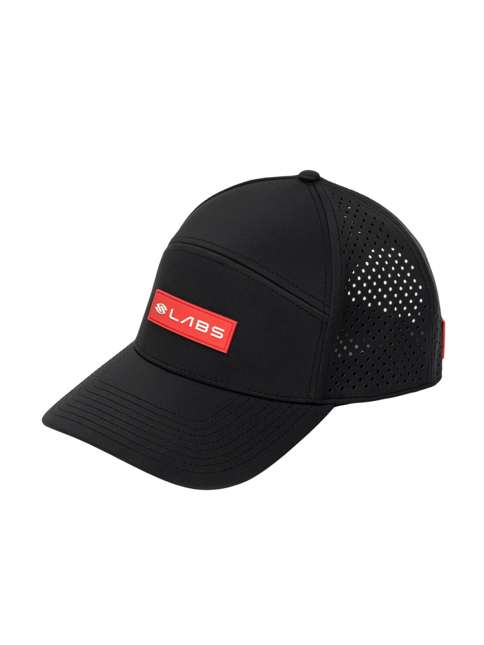 Three-quarter view of Selkirk LABS flat-bill snapback showcasing red LABS patch, perforated side panels on black background