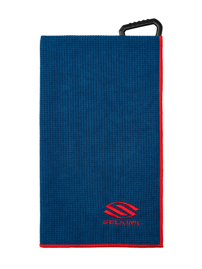Blue waffle-textured pickleball towel with red border and black clip, embroidered with red Selkirk logo and text.