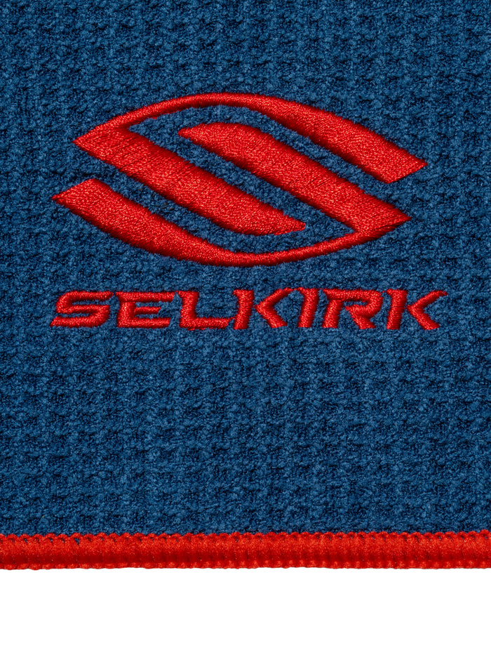 Red SELKIRK logo embroidered on blue textured fabric with red border