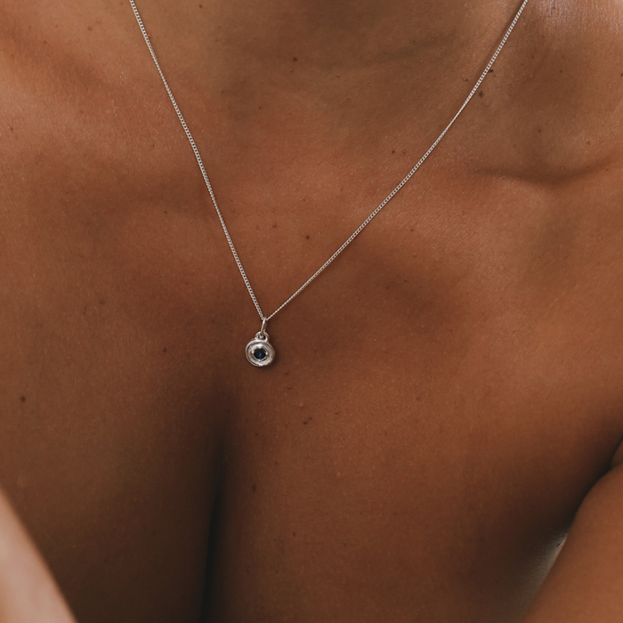 Silver necklace with a pendant on a person's chest
