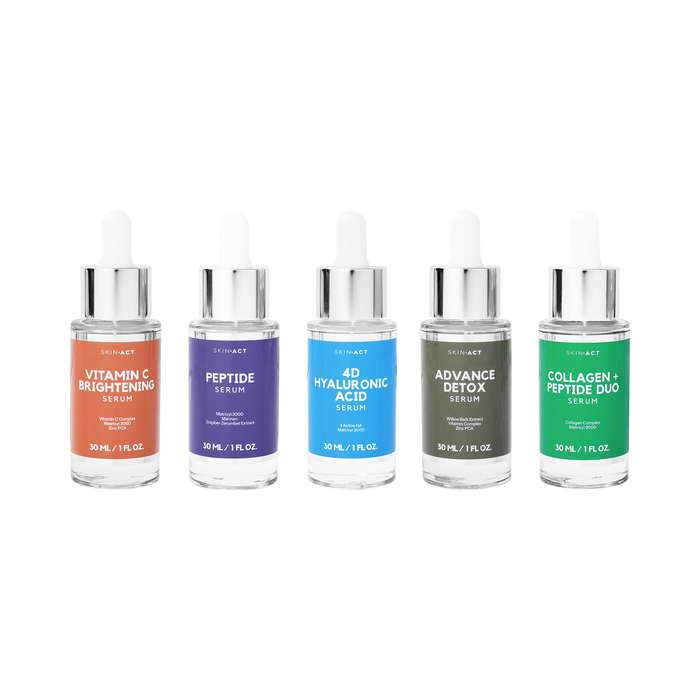 Set of five skincare serum bottles with colorful labels on a white background