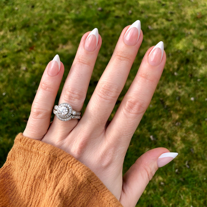 Sharp French - Press-On | Medium | Stiletto showing hand with classic french tip press-on manicure outdoors on green grass background