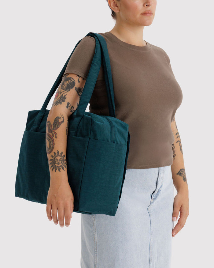 Teal carry-on tote bag worn on the shoulder with top handles